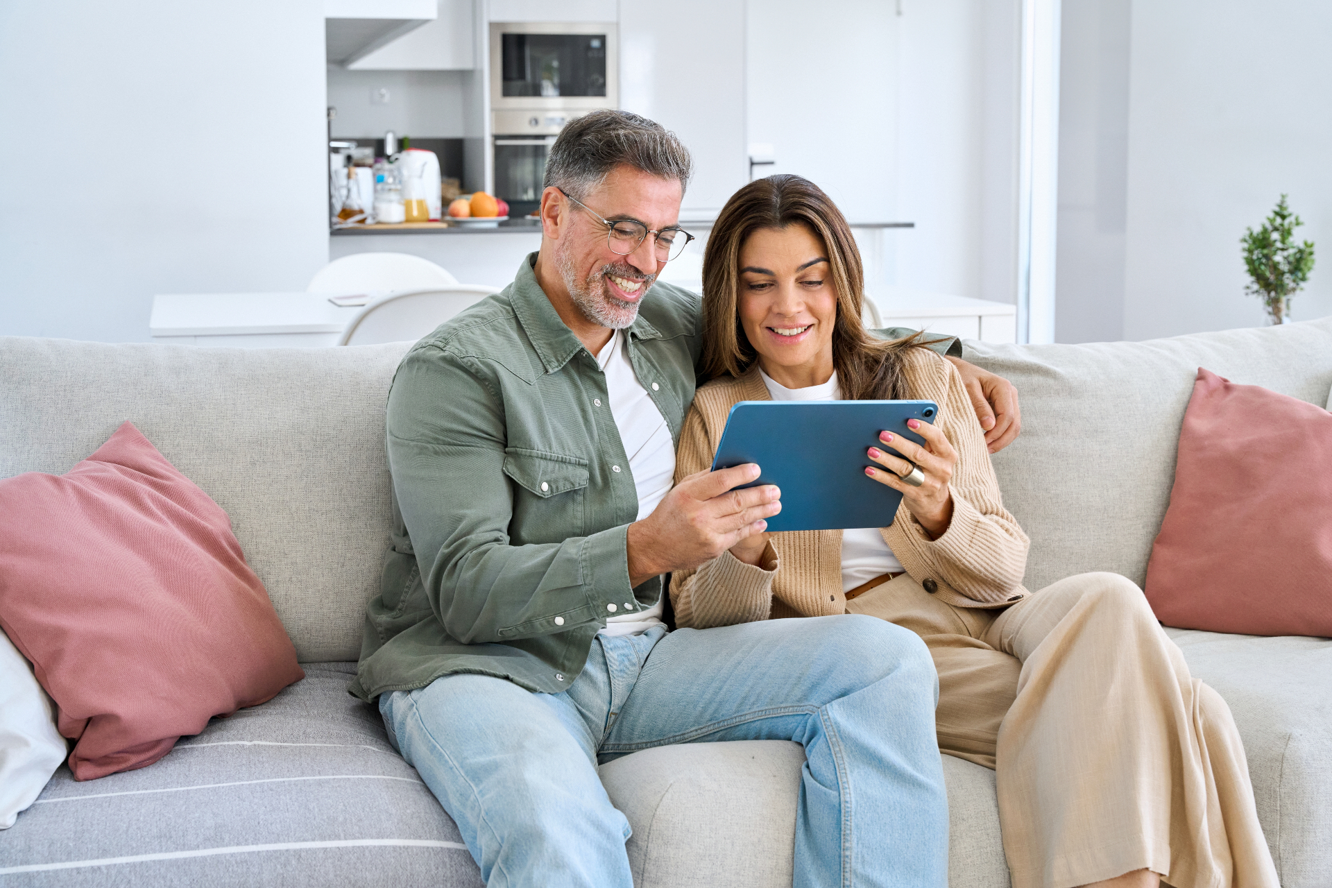 Casal analisando planos de saúde no tablet no conforto de casa